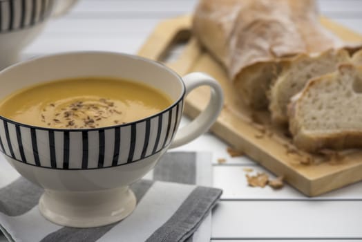 Retro styled mug full of Pumpkin soup with toasted cumin seeds on top