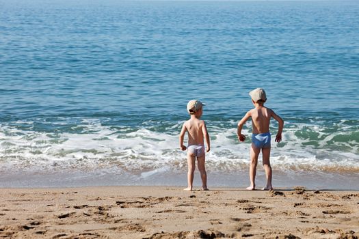 Summer vacations - two little child boy brothers walking sea sand beach