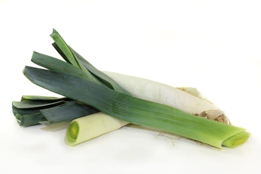 raw leek rods in front of white background