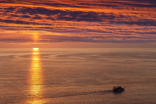 Summer vacations - water travel ship or boat sailing blue sea waves on sunset