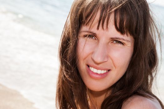 Summer vacations - smiling woman face on sea sand beach