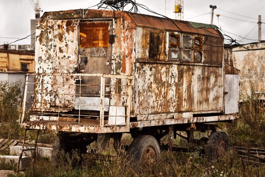 Old rusty wagon wheel vehicle on industrial building construction site