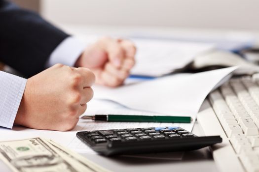 Angry business man hand banging fist on table in stress or problems at office workplace desk