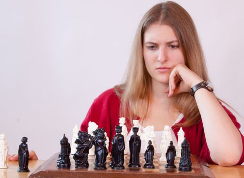 Pretty woman in red playing chess.