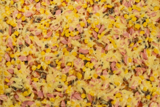 Large pizza closeup with cheese, sausage, corn and mushrooms, view from the top.