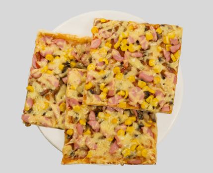 3 slices of pizza with cheese, sausage, corn and mushrooms on white plate, view from the top.