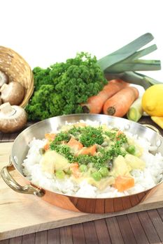 chicken frikassee with rice, carrots, capers and parsley in a pan