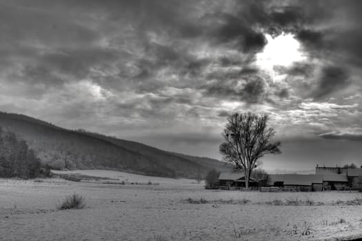 B/W photo of dramatic sky, and sun rays through the clouds