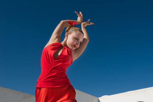 Attractive flamenco dancer wearing traditional red dress with flower in her hair