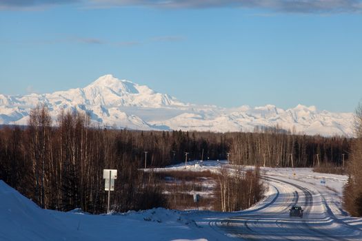 Road leading in to small town of Talkeetna with Denali in the background