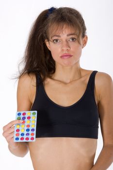 Frustrated young woman with pills to lose weight