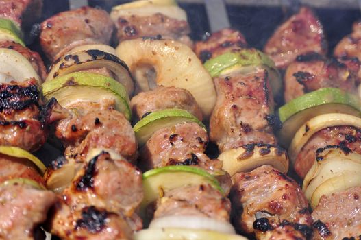 shish kebab with onion, squash (marrow) cooking on live coals