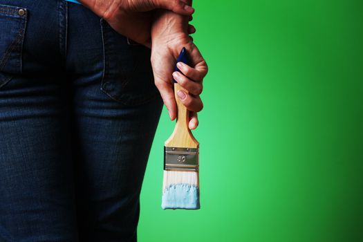 woman paints the wall brush