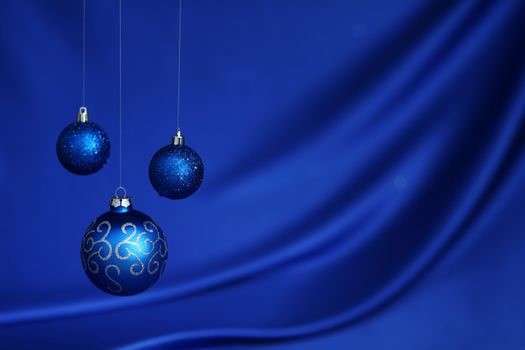 christmas balls on blue satin background