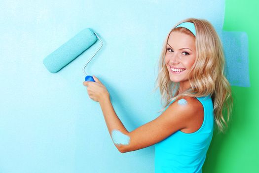 woman paints the wall roller