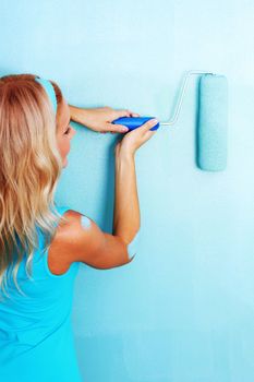 woman paints the wall roller