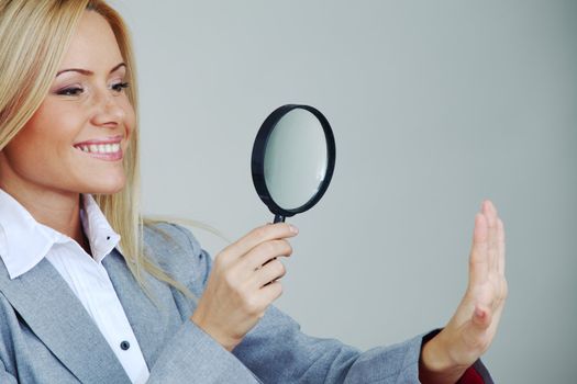 business woman looking through a magnifying glass