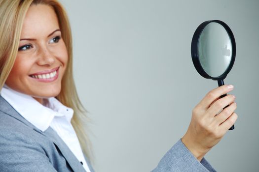 business woman looking through a magnifying glass