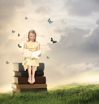 Little Blonde Girl Reading a Book  on Top of Books