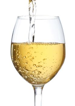 White wine being poured into a wine glass on white background