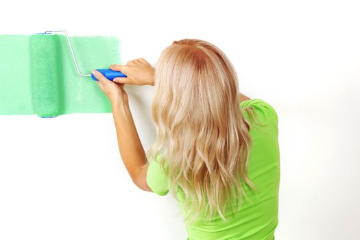 woman paints the wall brush