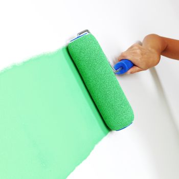 woman paints the wall brush