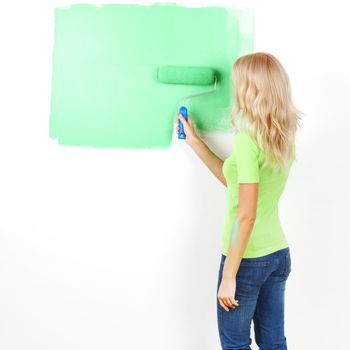 woman paints the wall brush