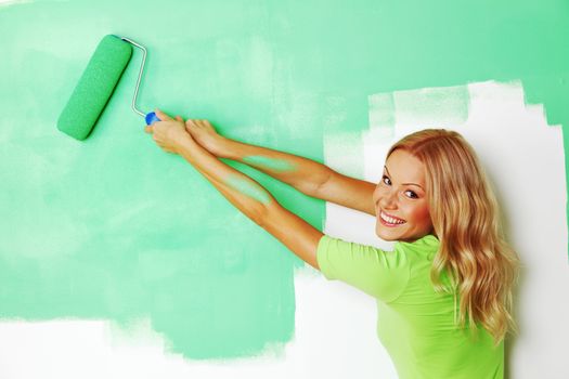 woman paints the wall brush