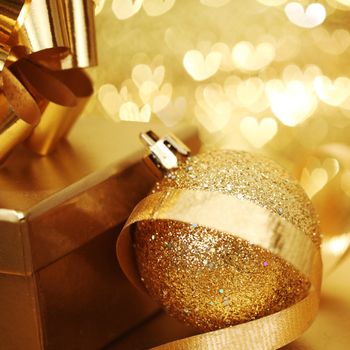 golden christmas ball on golden heart bokeh background