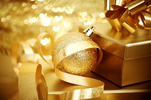 golden christmas ball on golden heart bokeh background