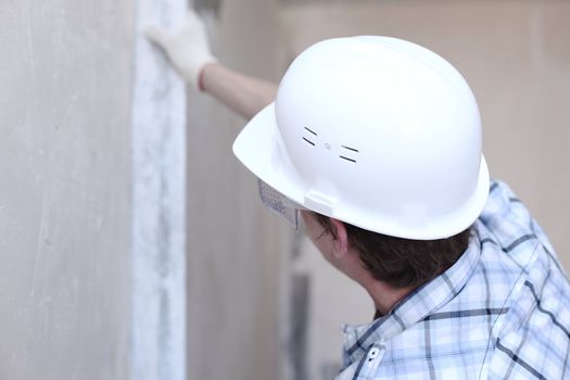worker aligns wall for directing