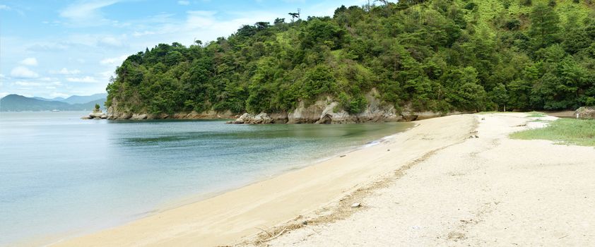 Panoramic photo of a beautiful Tsutsumigaura beach on the sacred Miyajima island near Hiroshima, Japan. 