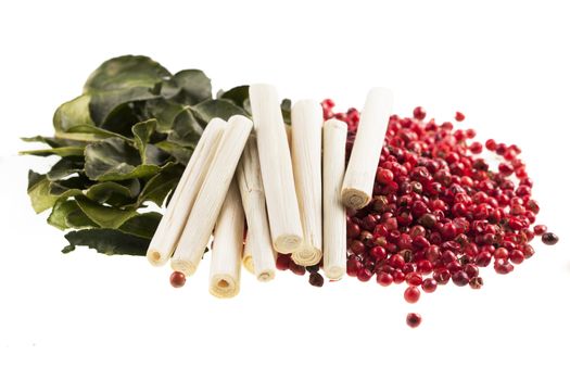 Thai cooking spices, kaffir lime leaves, lemon grass and pink peppercorns isolated on a white background