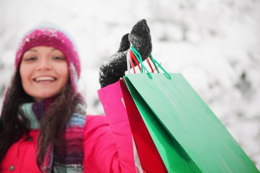 winter girl with gift bags on snow background