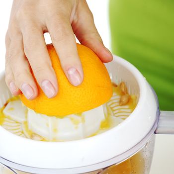 woman squeezes juice by juicer