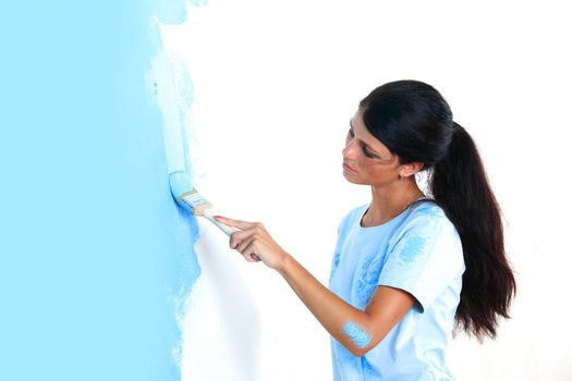 woman paints the wall brush