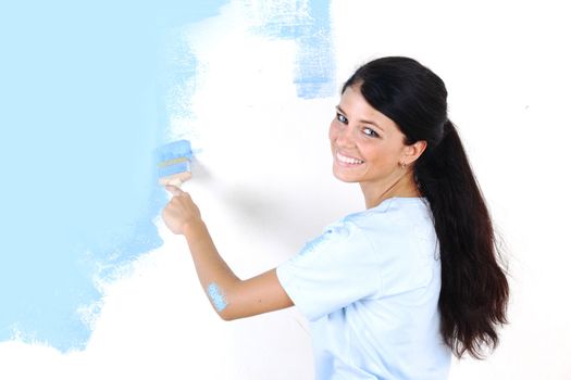 woman paints the wall brush