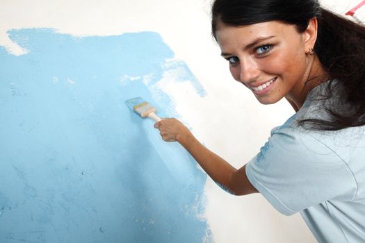 woman paints the wall brush