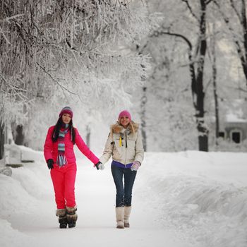 two winter women run by snow frosted alley