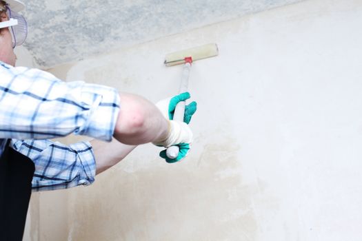 worker spends anchor roller on the wall