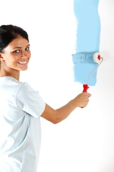 roller in woman hand paint on the wall