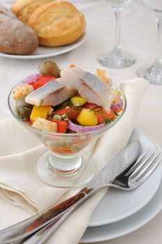 Salad with pieces of herring, white bread with vegetables and herbs