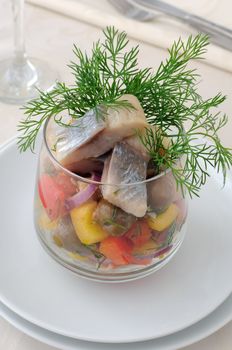 Salad with pieces of herring, white bread with vegetables and herbs