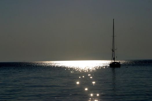 Boat sailing away at sundown
