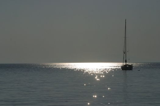 Boat sailing away at sundown