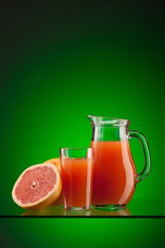 fresh grapefruit juice in the glass and jar over green