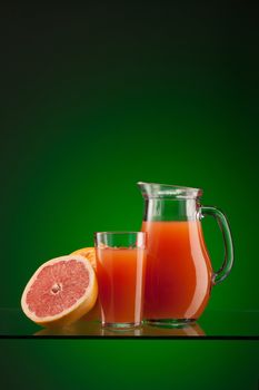 fresh grapefruit juice in the glass and jar over green