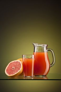 fresh grapefruit juice in the glass and jar over green