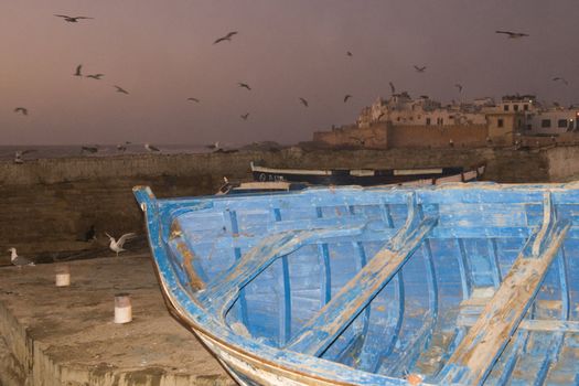 Small fishing boats on the dockside in the historic seaside village of Essaouira in Morocco.
