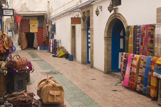 Shops selling local craft products in a narrow street in the fishing village of Essaouira, Morocco.